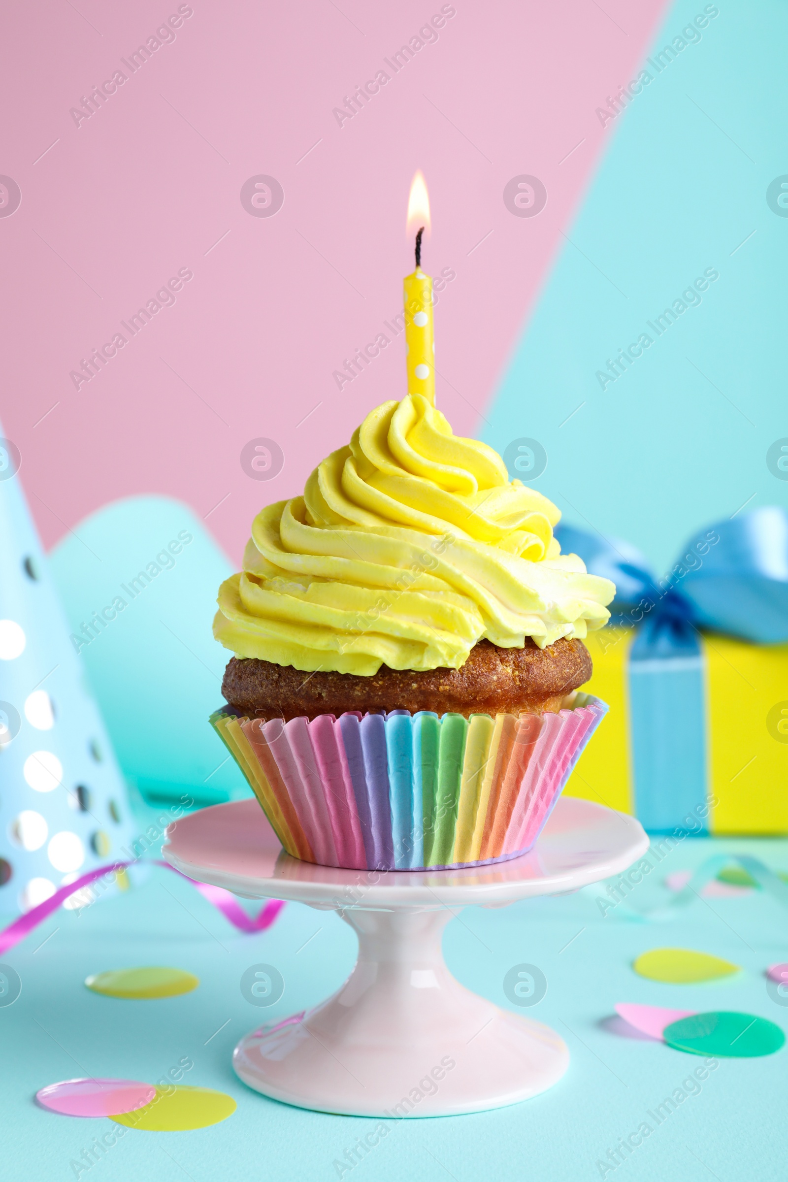 Photo of Delicious birthday cupcake with candle on color background