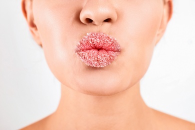 Photo of Young woman with sugar lips on white background, closeup