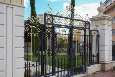 Photo of Beautiful black metal gates near house outdoors