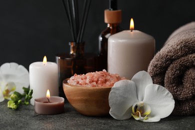 Photo of Beautiful composition with burning candles and different spa products on dark grey table