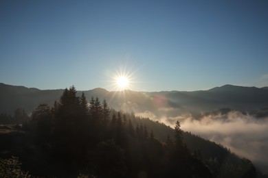 Photo of Beautiful view of mountains covered with fog at sunrise