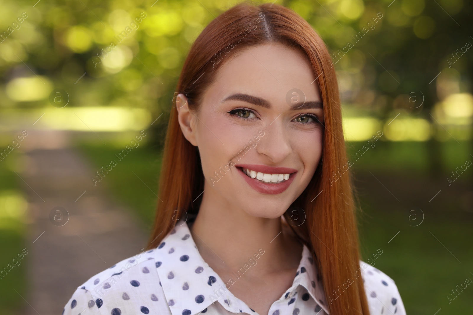 Photo of Portrait of charming young woman with beautiful smile in park. Attractive lady posing for camera