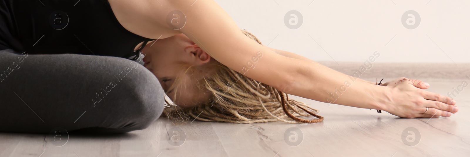 Photo of Young woman practicing yoga indoors