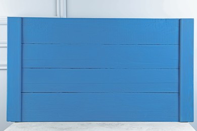 Photo of Texture of blue wooden board on table near white wall