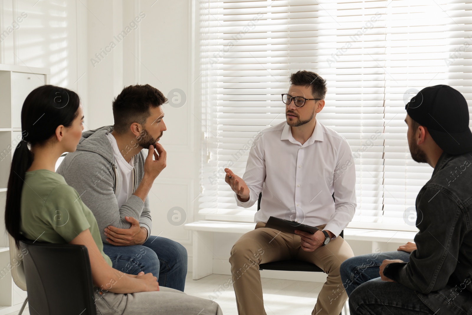 Photo of Psychotherapist working with group of drug addicted people at therapy session indoors