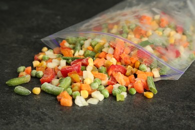 Photo of Zip bag with different frozen vegetables on grey table, closeup