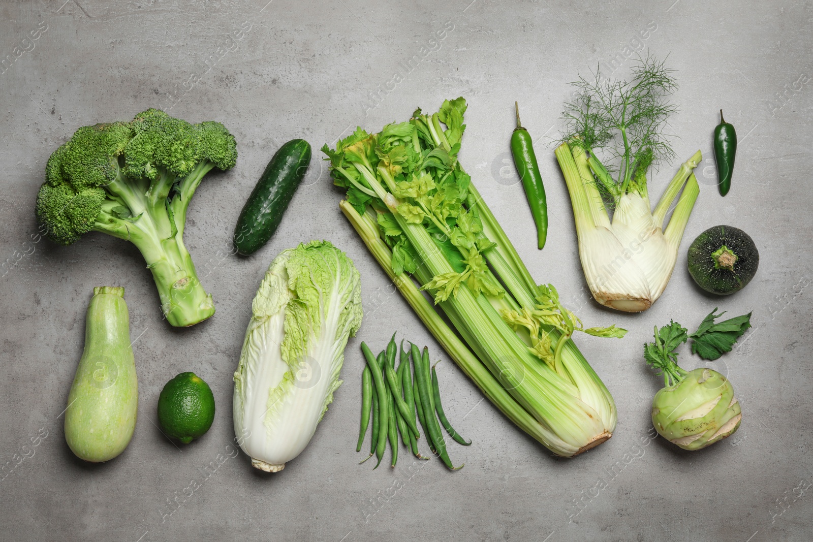 Photo of Flat lay composition of different green vegetables on grey table