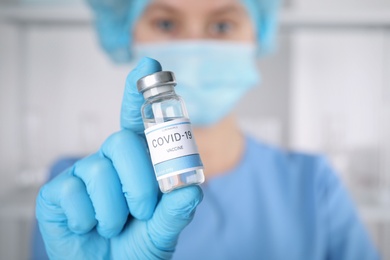 Photo of Doctor with coronavirus vaccine in laboratory, focus on hand