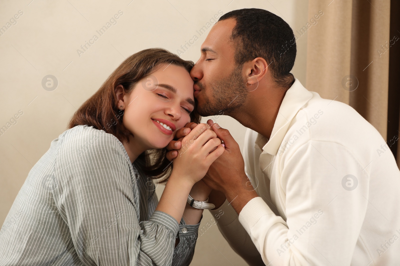 Photo of Romantic date. Guy kissing his girlfriend indoors