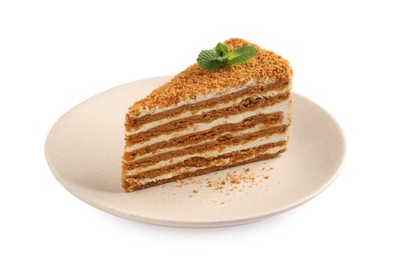 Photo of Slice of delicious layered honey cake with mint isolated on white