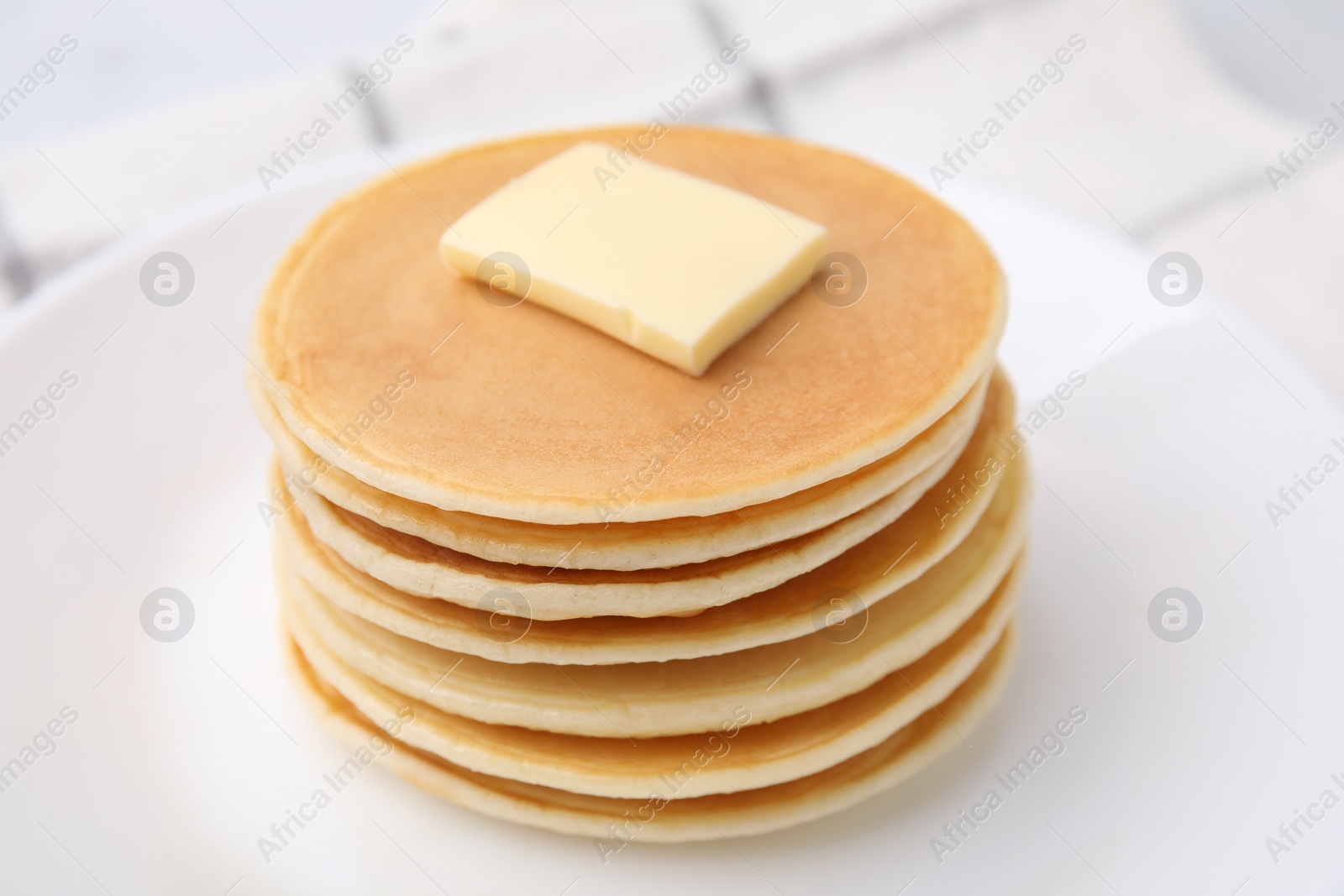 Photo of Delicious pancakes with butter on table, closeup