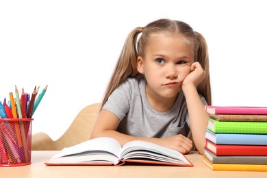 Photo of Little girl with stationery and books suffering from dyslexia at wooden table