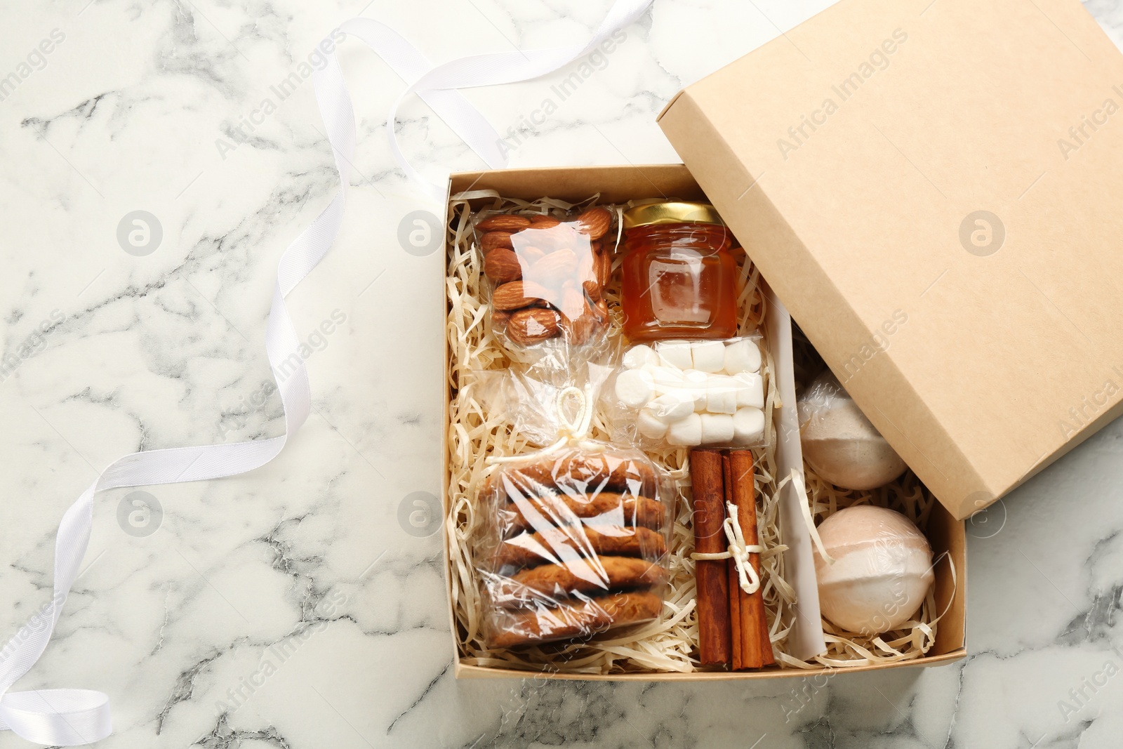 Photo of Stylish gift set on white marble table, flat lay. Space for text