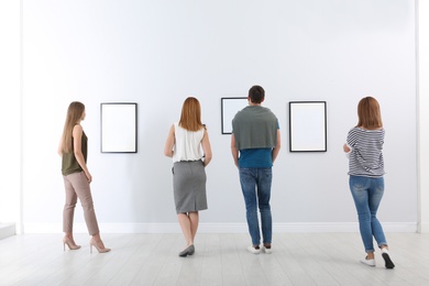 Photo of People viewing exposition in modern art gallery