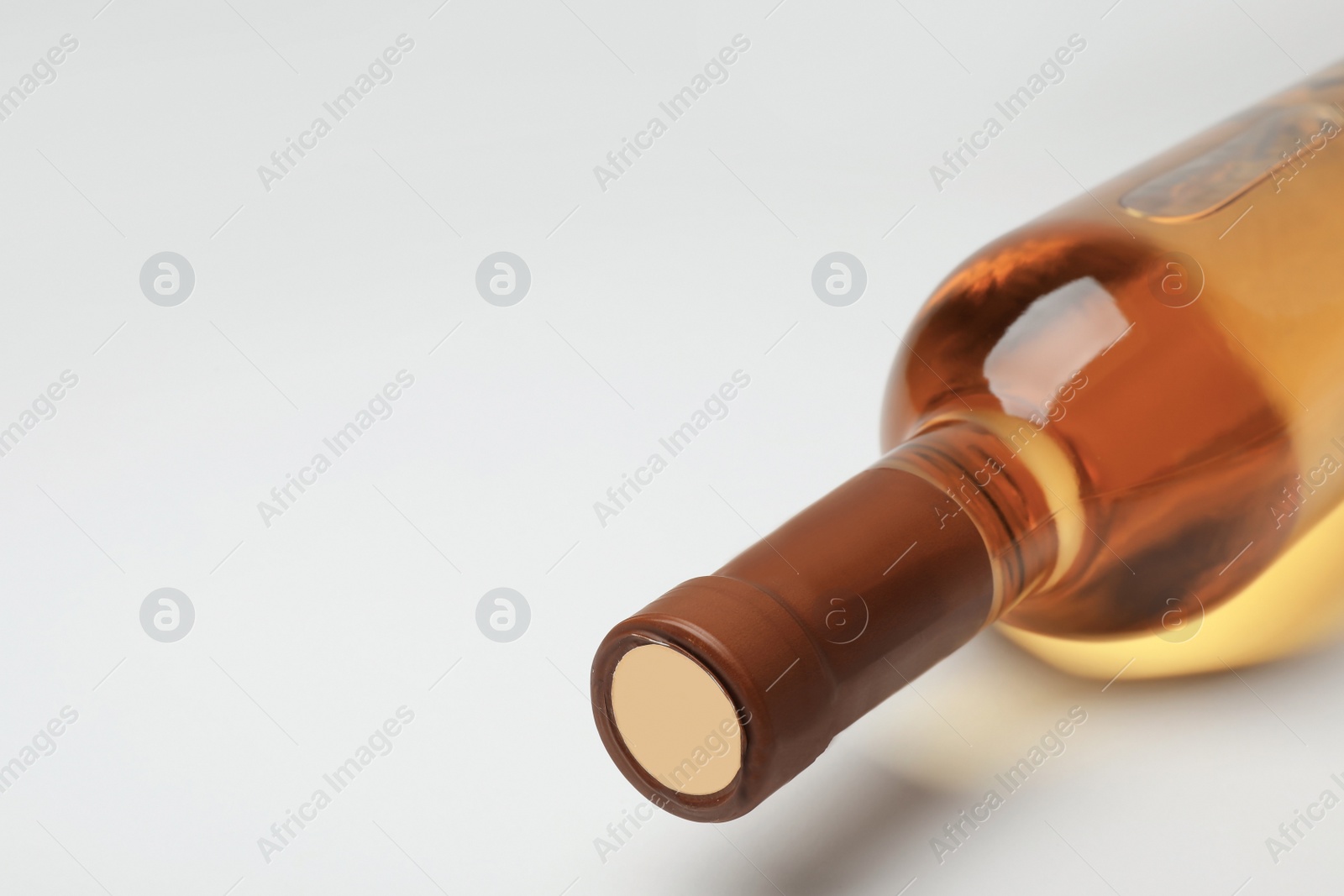 Photo of Bottle of expensive white wine on light background