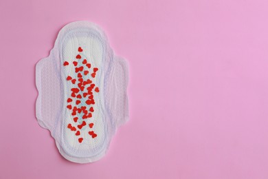 Photo of Menstrual pad and confetti on pink background, top view. Space for text