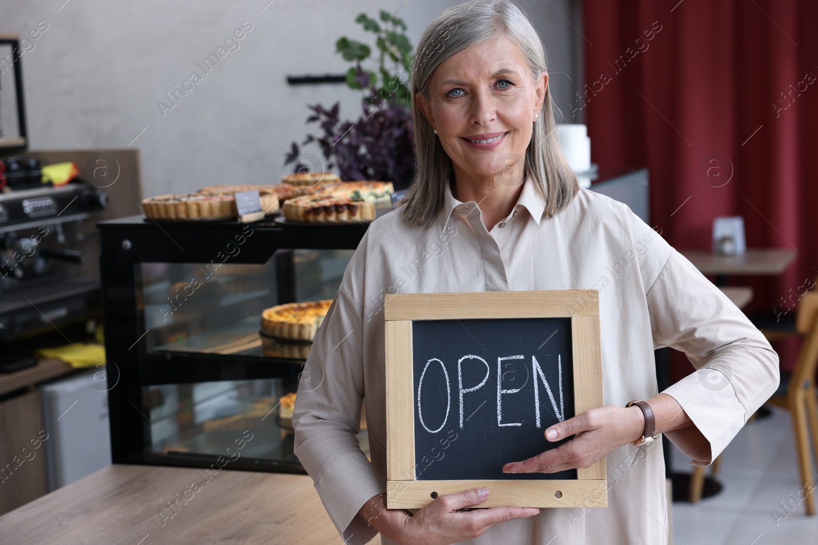 Photo of Happy business owner holding open sign in her cafe, space for text