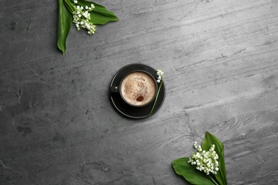 Flat lay composition with lily of the valley bouquets and coffee on grey background