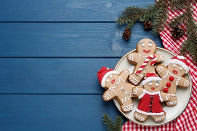 Photo of Delicious Christmas cookies and fir branches on blue wooden table, flat lay. Space for text