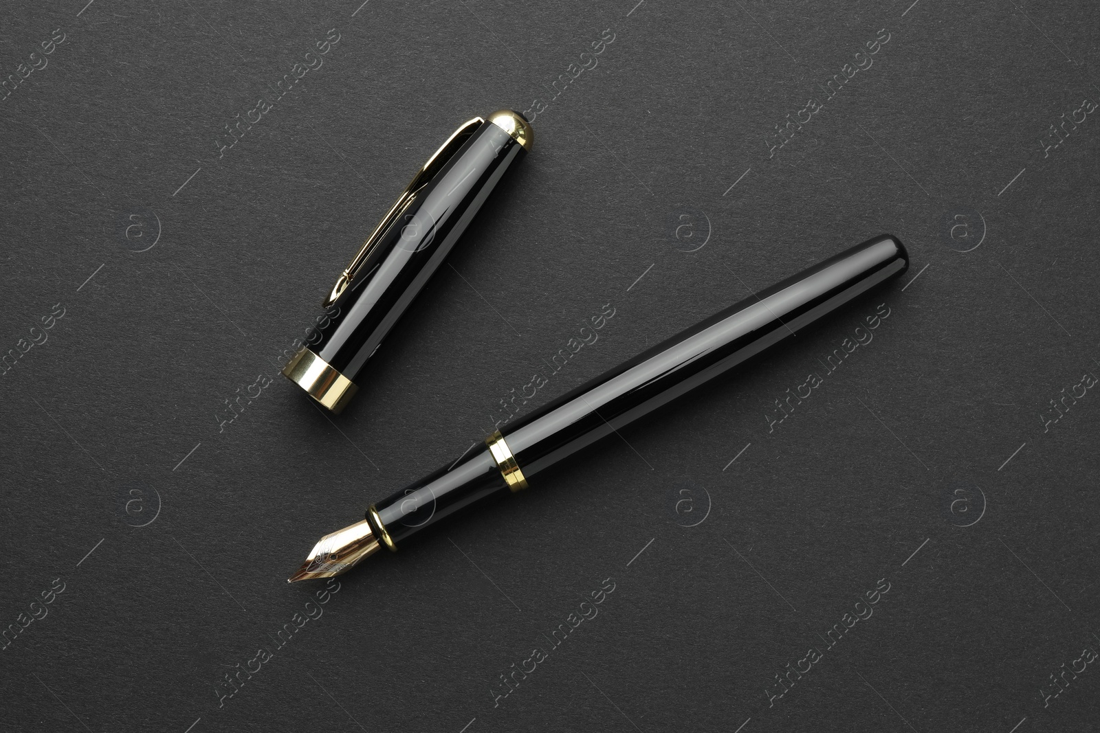 Photo of Stylish fountain pen with cap on black background, flat lay