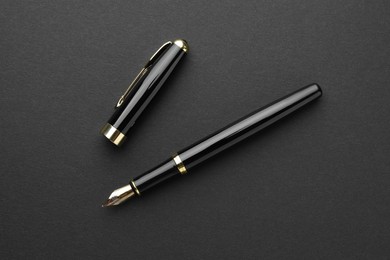 Photo of Stylish fountain pen with cap on black background, flat lay