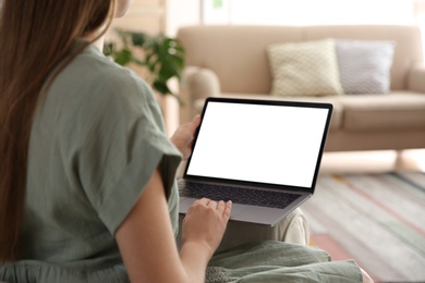 Photo of Woman using laptop at home, closeup. Space for design