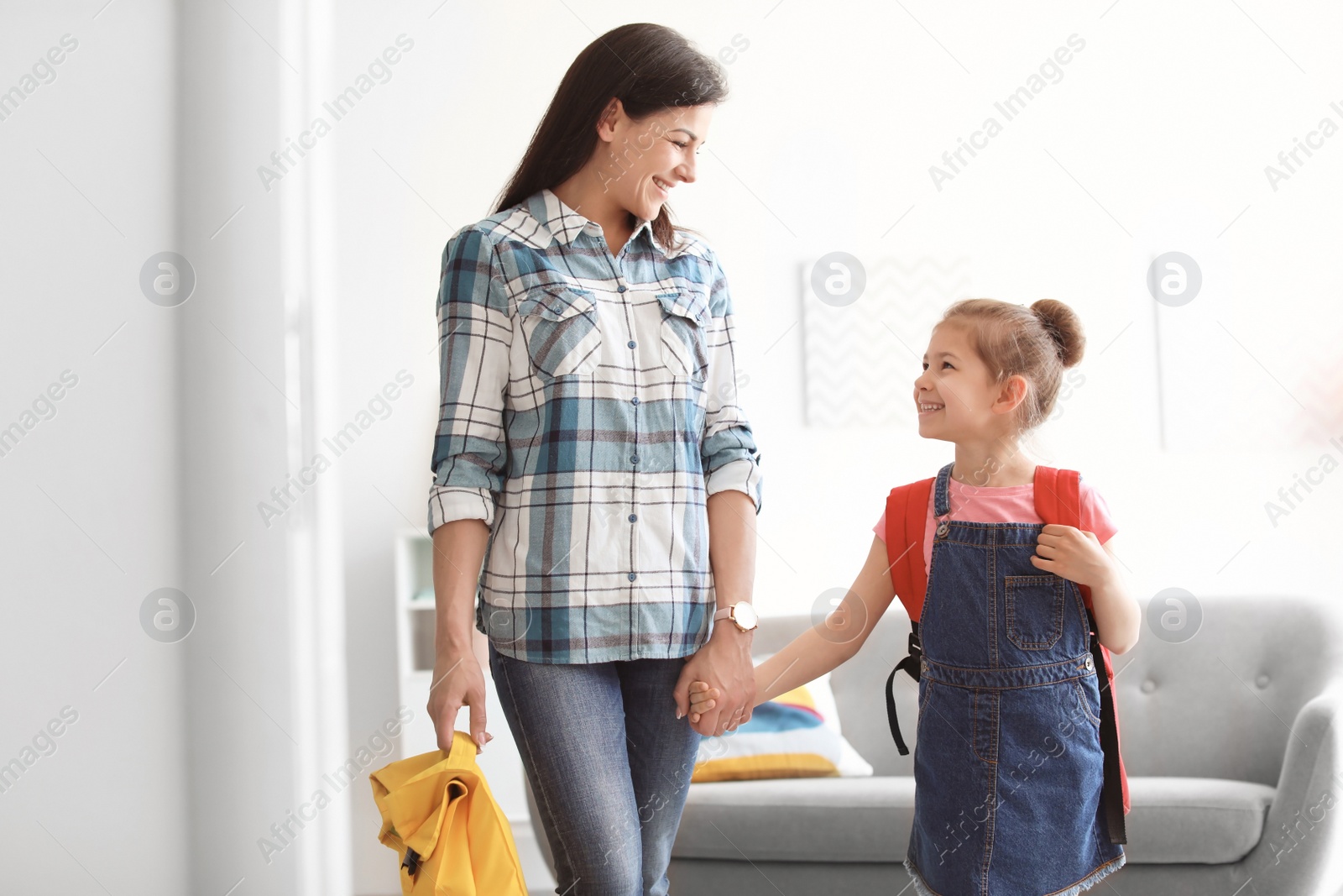Photo of Young woman taking her little child to school