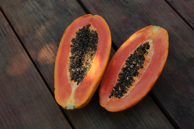 Photo of Fresh ripe cut papaya fruit on wooden table, flat lay