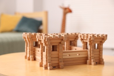 Photo of Wooden fortress on table indoors. Children's toy