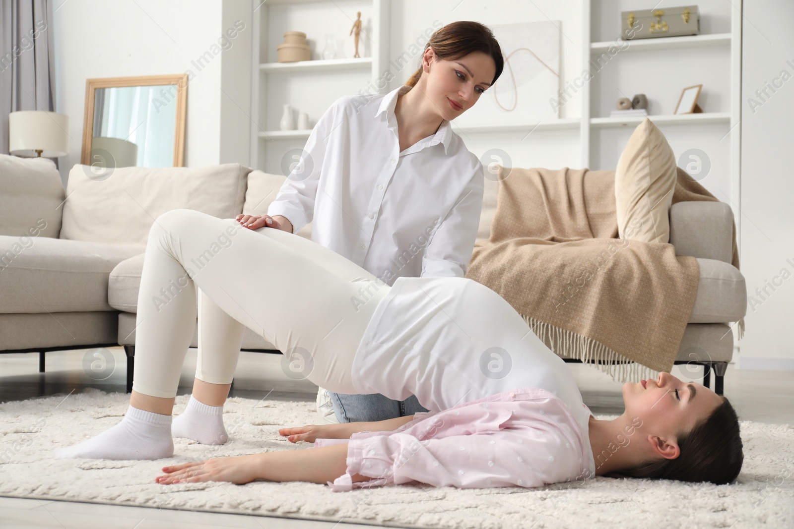 Photo of Doula working with pregnant woman at home. Preparation for child birth