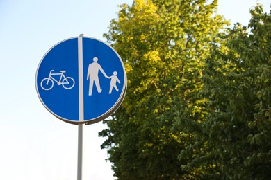 Photo of Traffic sign compulsory track for pedestrians and bicycles outdoors on sunny day, space for text