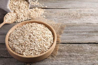 Photo of Bowl with oatmeal on wooden table. Space for text