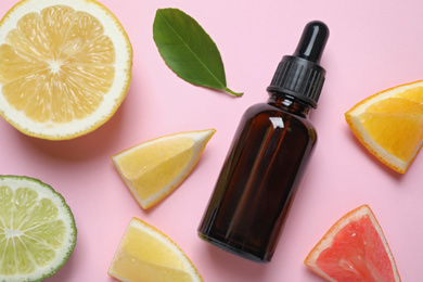 Photo of Flat lay composition with bottle of citrus essential oil on pink background