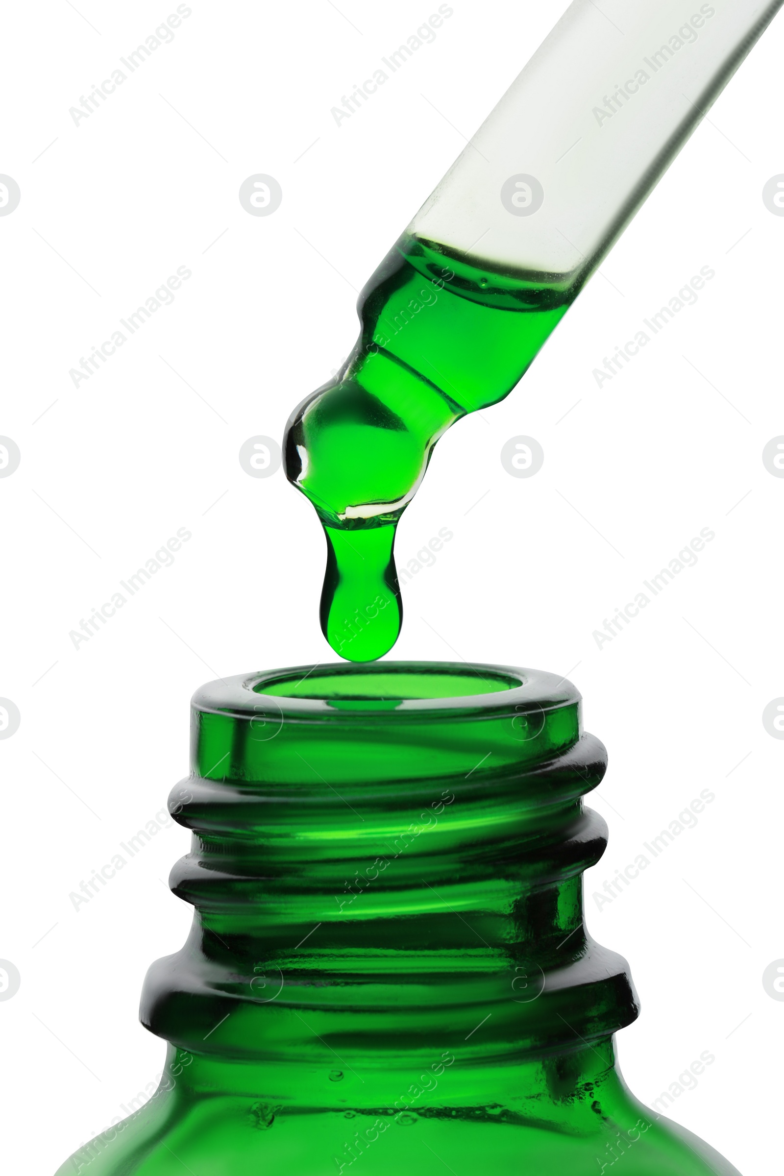 Photo of Dripping green facial serum from pipette into glass bottle on white background, closeup