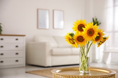 Photo of Beautiful bouquet of sunflowers in vase on table indoors. Space for text