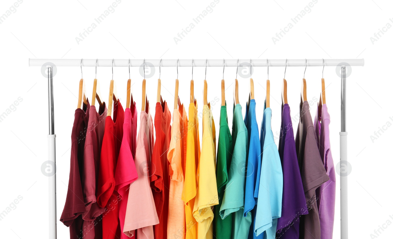 Photo of Many t-shirts hanging in order of rainbow colors on white background