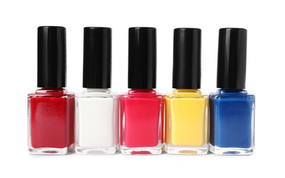 Photo of Bright nail polishes in bottles isolated on white