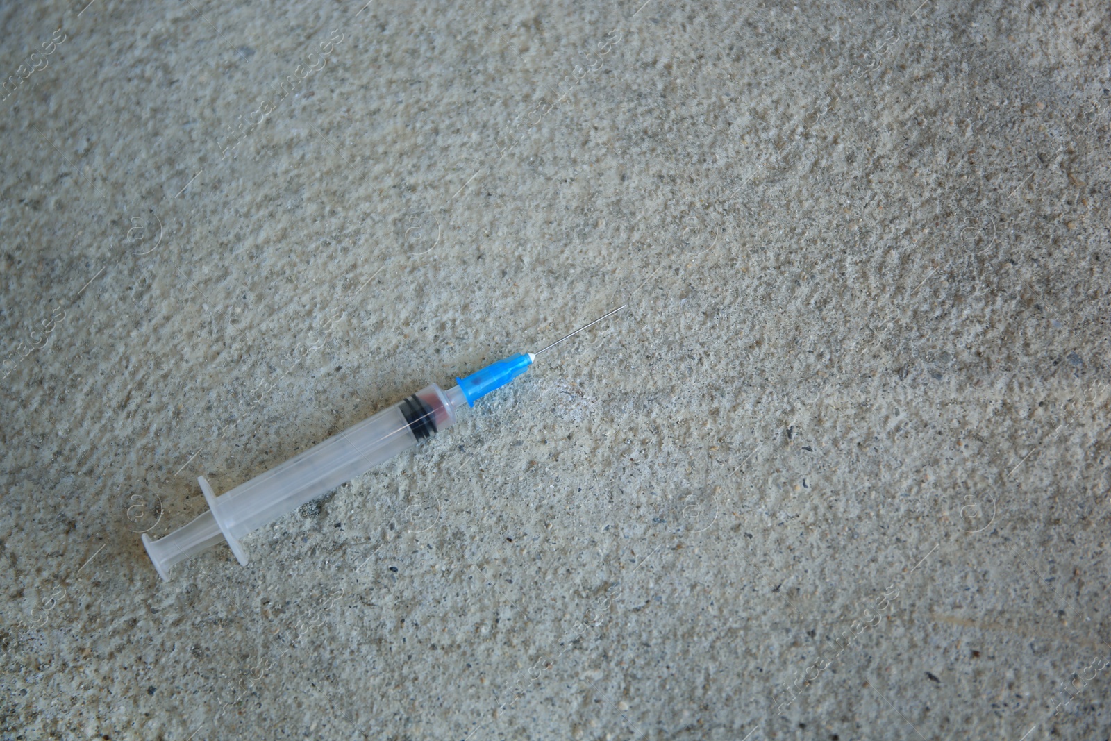 Photo of Empty syringe on stone surface, top view. Space for text