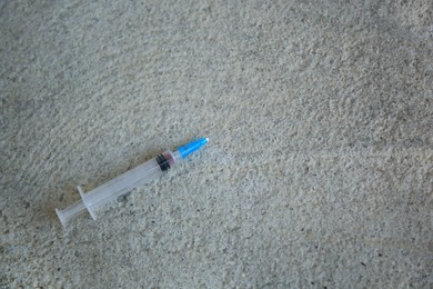 Photo of Empty syringe on stone surface, top view. Space for text