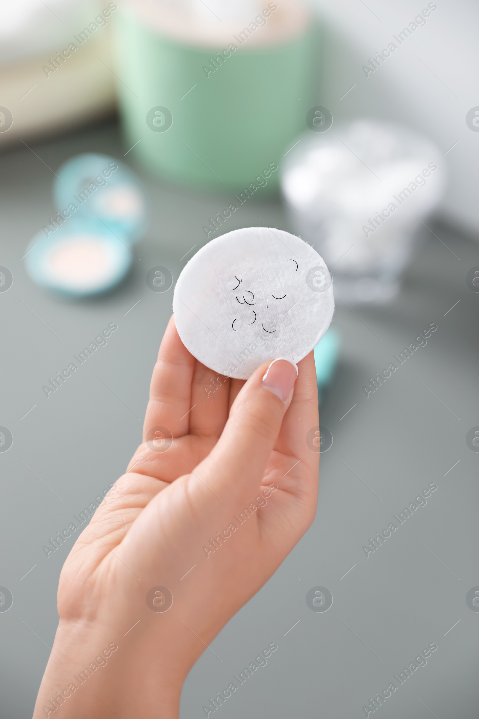 Photo of Young woman holding cotton pad with fallen eyelashes indoors