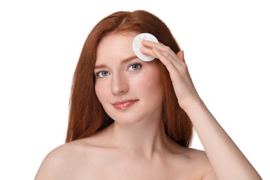 Beautiful woman with freckles wiping face on white background