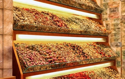 Photo of Shelves with different kinds of tea at market