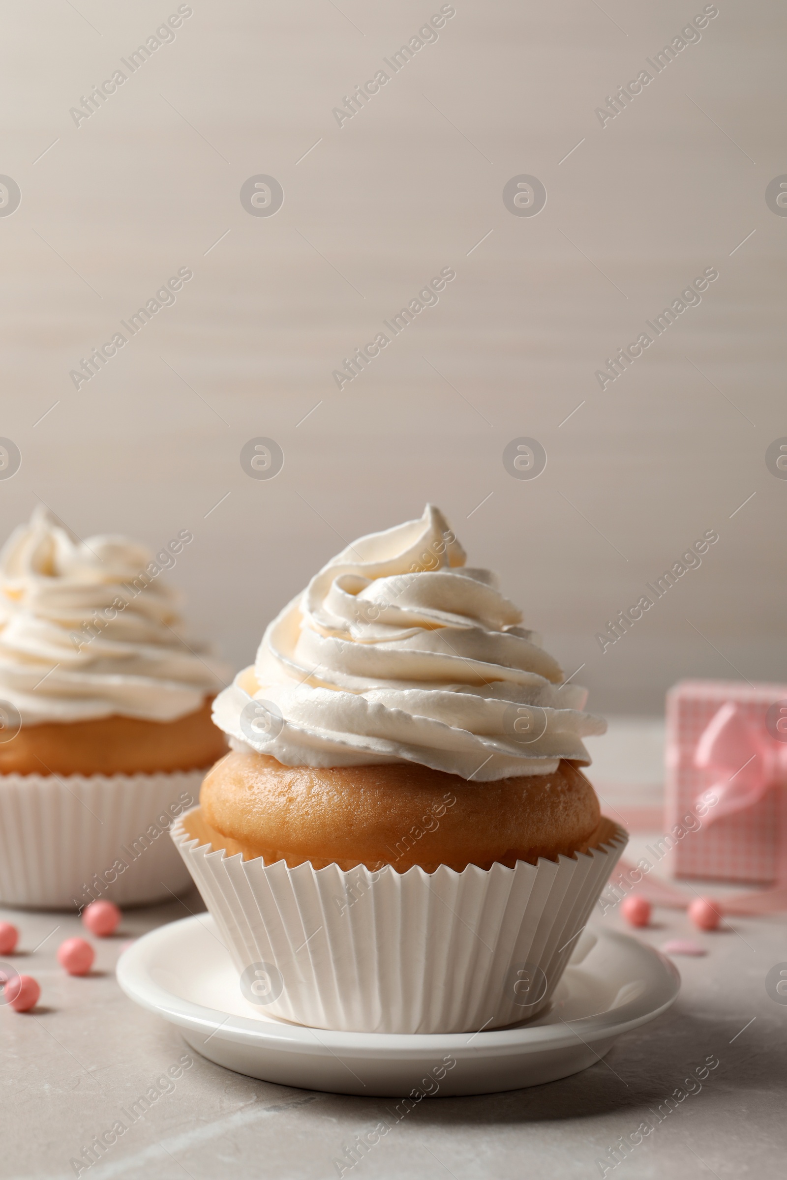 Photo of Delicious cupcakes decorated with cream on light grey table