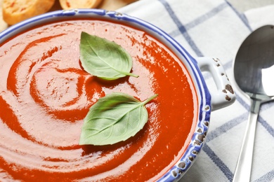 Photo of Dish with fresh homemade tomato soup on table, closeup