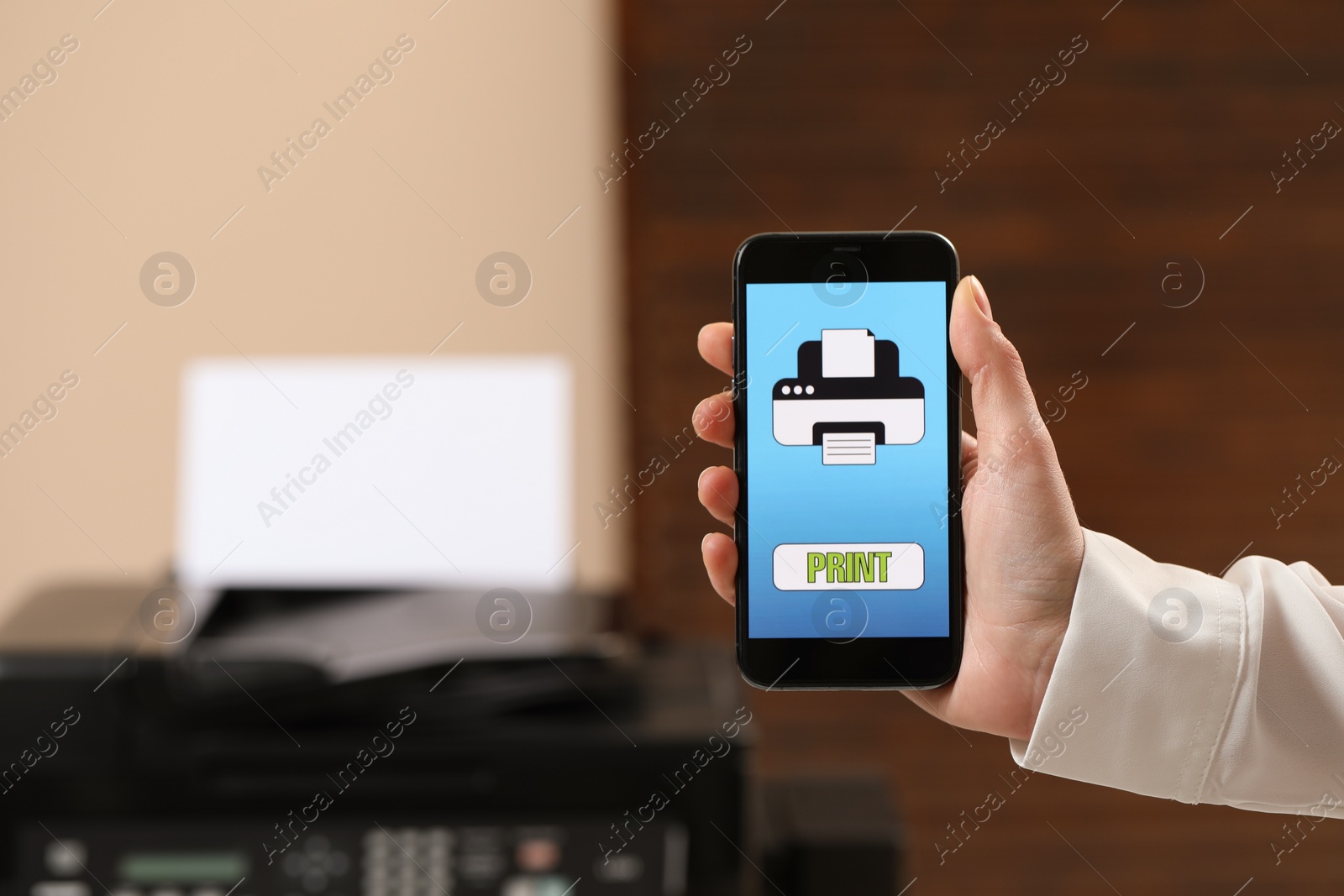 Photo of Man using printer management application on mobile phone in office, closeup and space for text