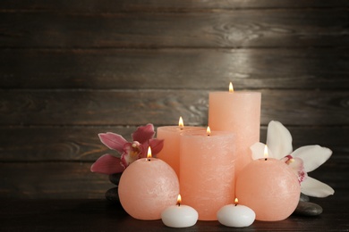 Photo of Beautiful composition with lit candles and flowers on table