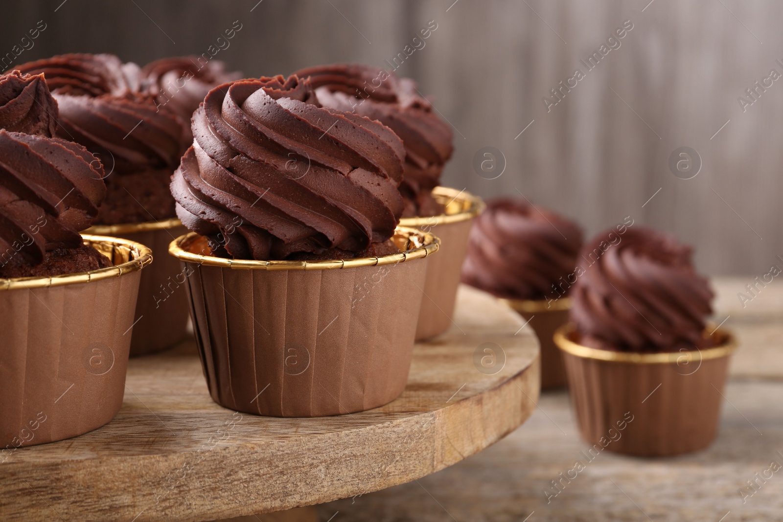 Photo of Delicious chocolate cupcakes on wooden table, closeup