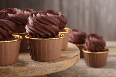 Delicious chocolate cupcakes on wooden table, closeup