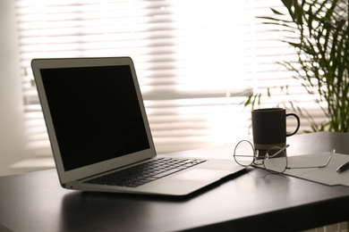 Photo of Modern laptop on office table. Stylish workplace