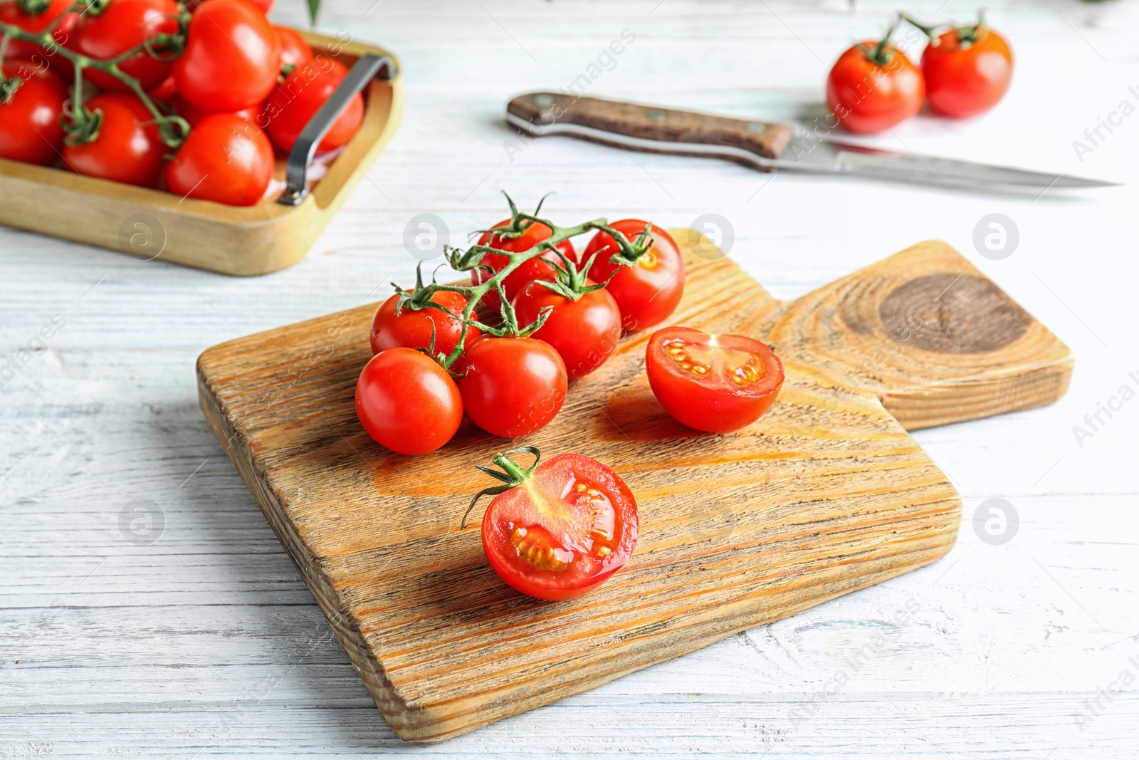 Photo of Wooden board with fresh ripe tomatoes on table